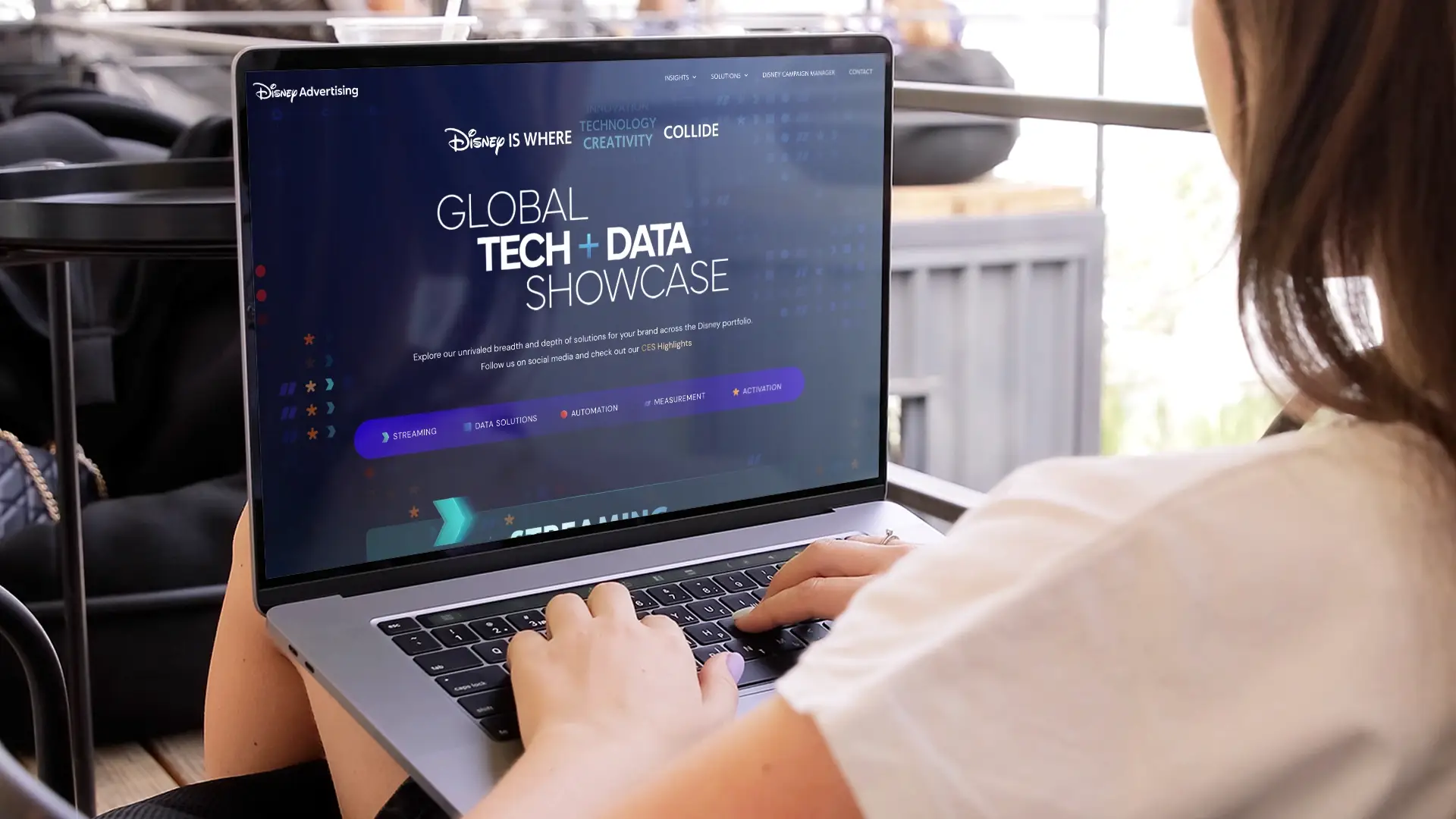 Closeup photo of a person using a laptop with the Disney Advertising website displayed on the screen.