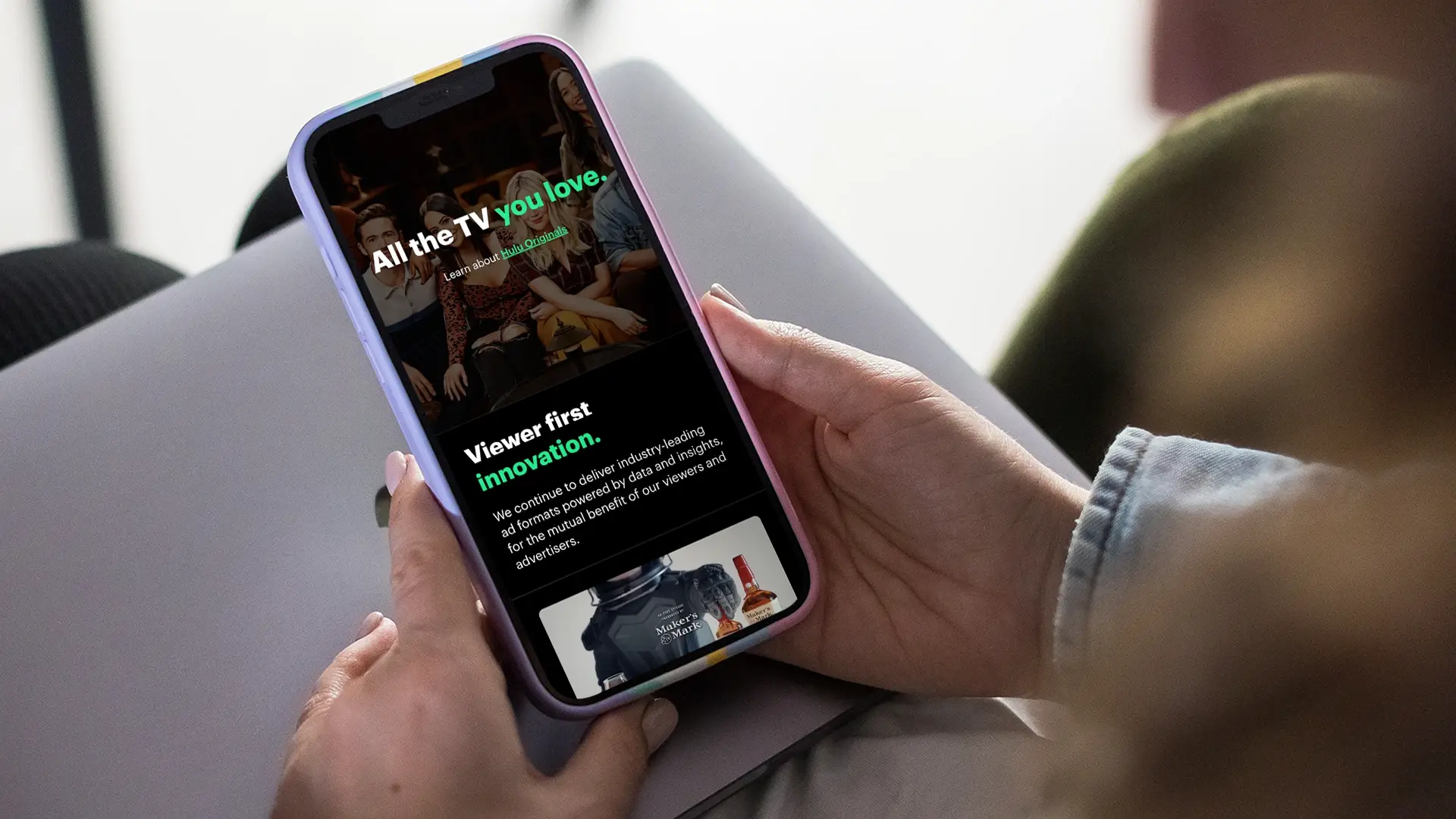 Closeup photo of a person using a smartphone with the Disney Advertising website displayed on the screen.